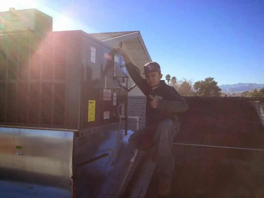 HVAC technician performing AC Tune-Up on a rooftop unit in Cullowhee